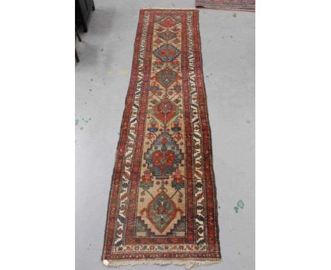 Large Persian runner, having seven conjoined medallions to the biscuit ground in multiple borders, approximately 400 x 100cm