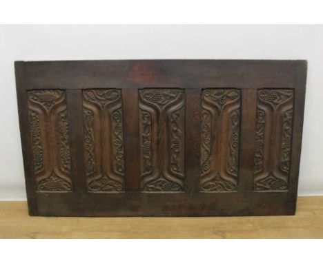 Large early carved oak panel with five recessed relief carved enriched parchemin panels, each with stylised foliate and fruit