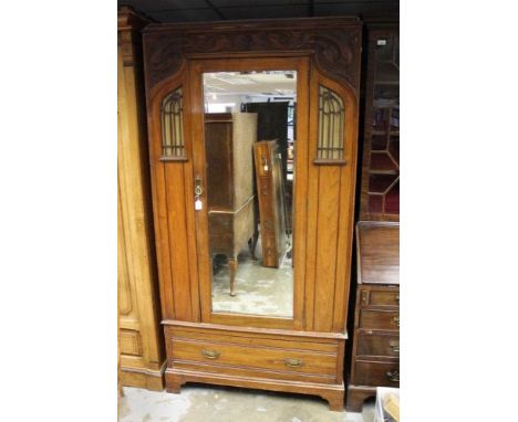 Edwardian Art Nouveau walnut wardrobe with glazed panels to the frieze and carved floral scrollwork, enclosed by mirrored doo