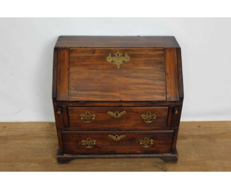 George III fruitwood apprentice bureau, with hinged slope enclosing a fitted interior, two drawers below on bracket feet, 50c