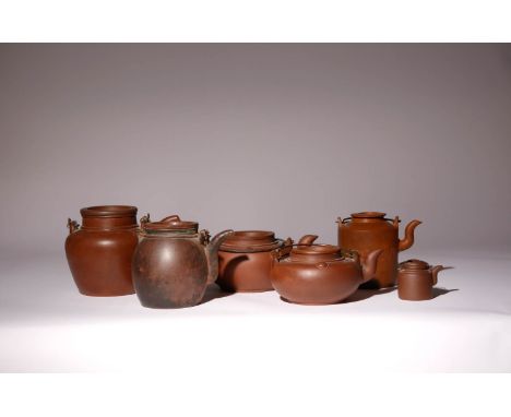 SIX CHINESE YIXING TEAPOTS AND COVERS LATE 19TH CENTURY AND LATER Variously shaped and decorated, each mounted with a double 