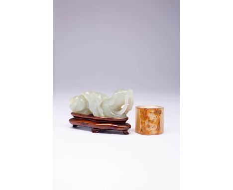 A CHINESE AGATE ARCHER'S RING AND A JADE CARVING OF A DOG LATE QING DYNASTY The ring carved with Liu Hai, his toad and a stri