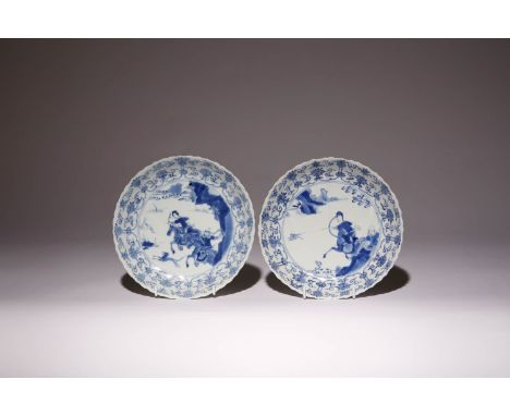 A PAIR OF CHINESE BLUE AND WHITE MOULDED 'HUNTING' DISHES KANGXI 1662-1722 Each depicting equestrians in pursuit of their qua