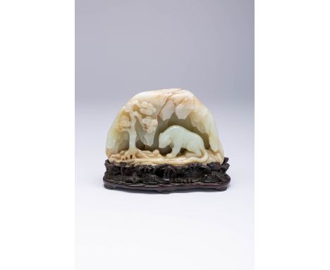 A CHINESE CELADON JADE BOULDER QING DYNASTY OR LATER Carved in relief with a tiger in a cave beside a pine tree, the stone wi