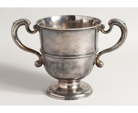 A FINE GEORGE I SILVER TWO HANDLED PEDESTAL CUP with scrolled handles, 6ins high, 5.25 ins diameter with crest. London 1723, 
