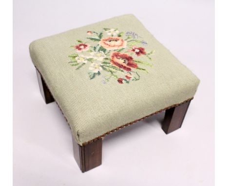 A SQUARE STOOL with needlework top. 11ins high