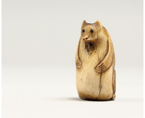 A CARVED BONE NETSUKE OF A BEAR 1.25ins