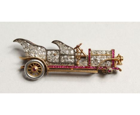 A GOLD DIAMOND SET VINTAGE CAR BROOCH 1.75ins long (one wheel missing)