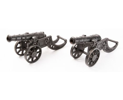 A pair of cast iron model cannon, the 9 1/2 inch five stage barrels with harp motif and rounded cacscabel, on pierced frame t