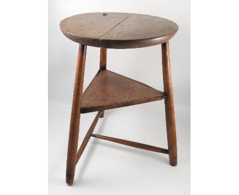 A 19th century country cricket table, possibly sycamore, with thick top, joined by a triangular shelf and turned T stretcher,