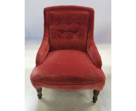 A 19th century button back nursing chair, upholstered in pink dralon fabric, raised on front turned legs, one back leg stampe