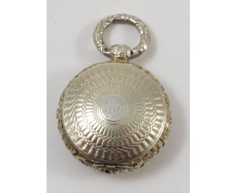 A Georgian silver gilt vinaigrette, of circular stop watch form engine turned decoration and floral edge, with pierced leaf g