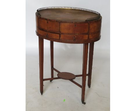 A 19th century circular mahogany side table, with gilt metal gallery to the oval top, with two cupboard doors opening to reve