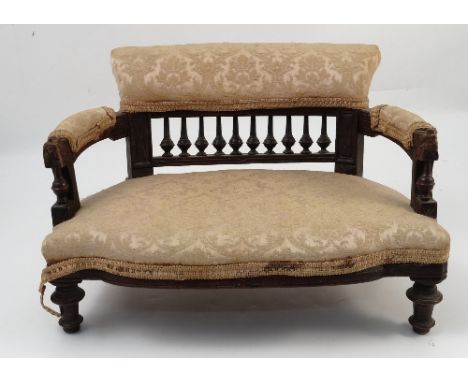 A Victorian miniature mahogany framed two seater settee, with upholstered back with spindles below, open arms, stuff over sea