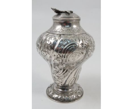 An 18th century silver tea caddy, of baluster form, with embossed and fluted decoration of flowers and leaves, with flower fi