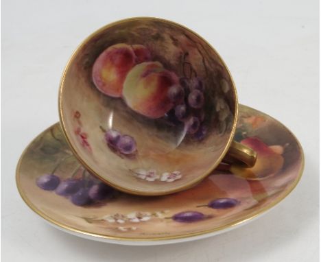 A Royal Worcester miniature cabinet cup and saucer, the interior of the cup and saucer decorated fruit to a mossy background 