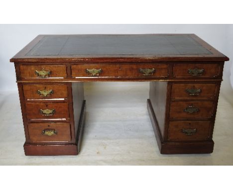 An Edwardian oak pedestal desk, fitted three frieze drawers below the leather inset top, raised on two pedestals of three dra