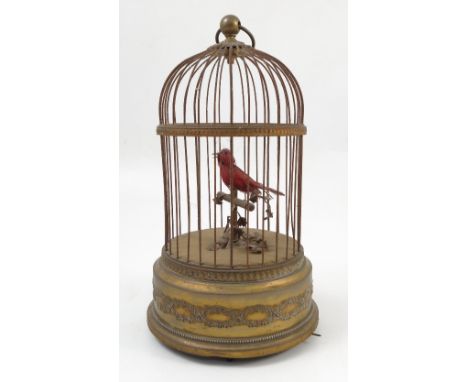An early 20th century French bird in a cage musical automaton, the red bird sitting on a stand with leaves, marked Made in Fr