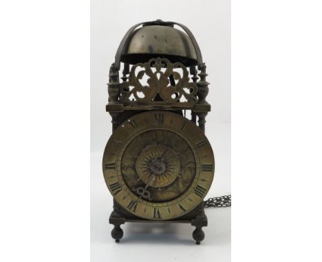 An 18th century brass lantern clock, with Roman numerals to the chapter ring, engraved with tulips and having an alarm dial, 