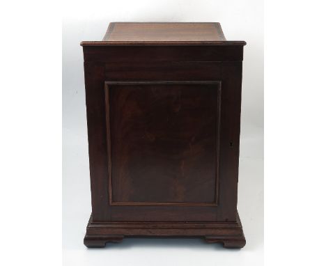 A Georgian mahogany box folio or sheet stool, with ebony inlaid concave seat, cupboard door to one end and raised on ogee bra