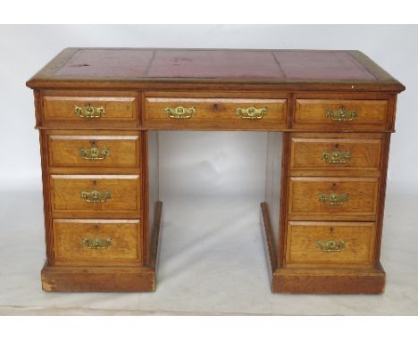 A late Edwardian oak pedestal desk, fitted with three short drawers to the frieze, raised on two pedestals of three graduated