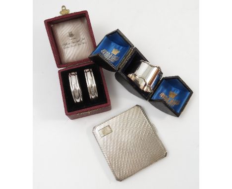 A pair of hallmarked silver napkin rings, retailed by Dunhill, weight 1oz, together with a hallmarked silver cased napkin rin