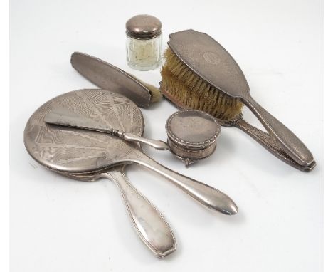 A hallmarked silver dressing table set, comprising two hand brushes, a brush and a hand mirror, with engine turned decoration