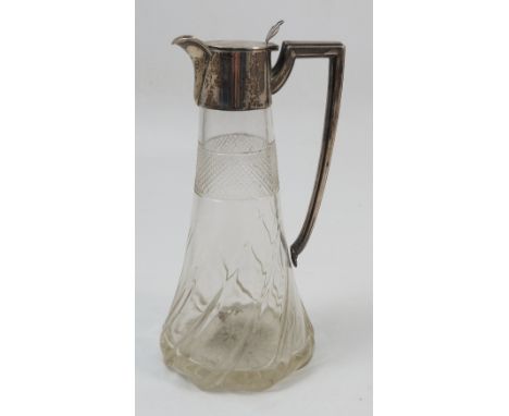 A silver mounted glass claret jug, the tapering wrythen moulded glass body with diamond cut band having a silver angular hand