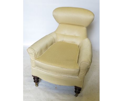 A 19th century upholstered armchair, with deep button back, raised on front turned legs 