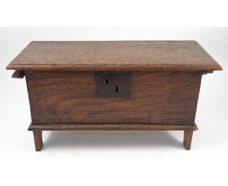 A 19th century miniature elm coffer, having a plain rising lid, raised on short bracket feet, width 22ins