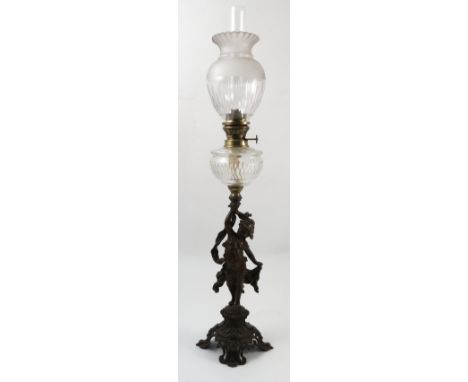A Victorian spelter oil lamp, the base formed as a girl with ribbon on a pierced and embossed base, with glass oil reserve an