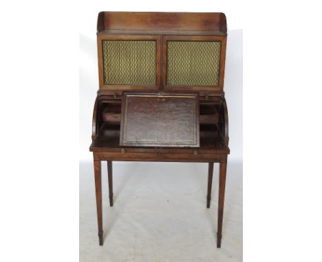 A late 19th century mahogany cylindrical bureau, with tray top shelf over two grilled cupboards over the cylinder, the cylind