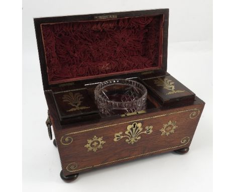 A 19th century rosewood sarcophagus shaped tea caddy, with brass inlay to the top and front, the interior fitted with two can