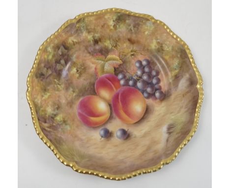 A Royal Worcester cabinet plate, hand painted with fruit to a mossy background by N Creed, to a shaped gilt edge, diameter 10