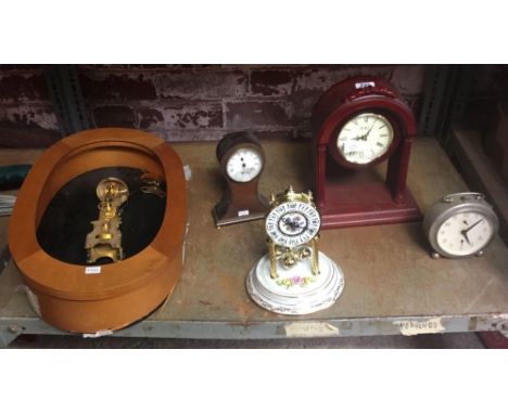 SHELF WITH VARIOUS CLOCKS INCL; A JUNGHANS PETER ALARM CLOCK, A PART BUILT HERMLE STRIKING CLOCK, A WOODEN ARCHED CLOCK &amp;