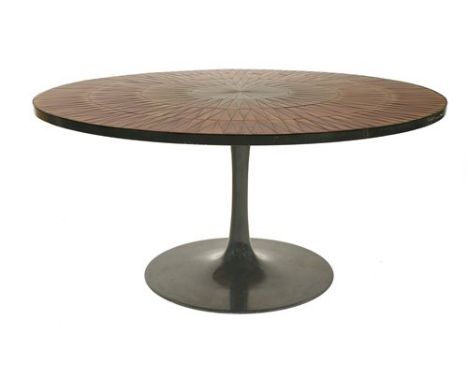 A tile top dining table, the circular top with radiating patterns in orange, on a black painted stand , 150cm wide 73.5cm hig