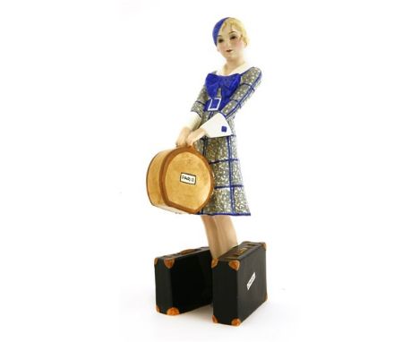 A Goldscheider figure of a woman holding a hat box and standing with two suitcases, by Josef Lorenzl, no. 7064, incised facsi