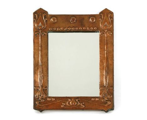 An Arts &amp; Crafts embossed copper mirror, of rectangular form, each side with raised arrow-topped details and an embossed 