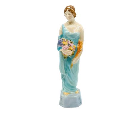 In style of Phoebe Stabler. Figure of a lady portrayed as Autumn, in a pale blue colorway dress, and holding a bouquet of wil