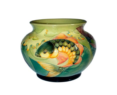 Inspired by a Sally Tuffin design. A large round vase in a light green glaze ground. Features a shoal of fish. Excellent tube