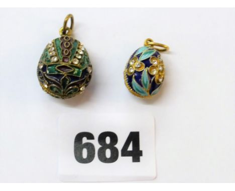 A Russian silver gilt &amp; enamel egg pendent together with similar. (2)