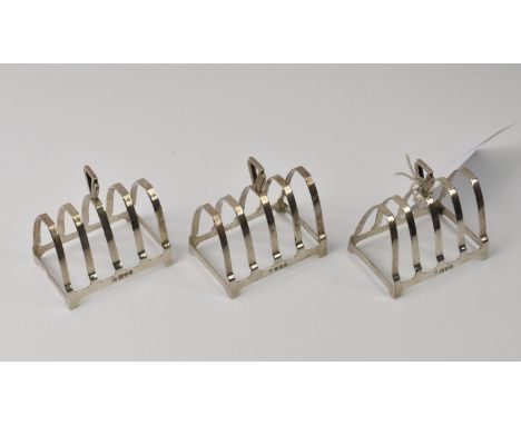 Three silver Art Deco four section toast racks William Neale &amp; Sons, 1937, two Chester the other Birmingham, all stamped 