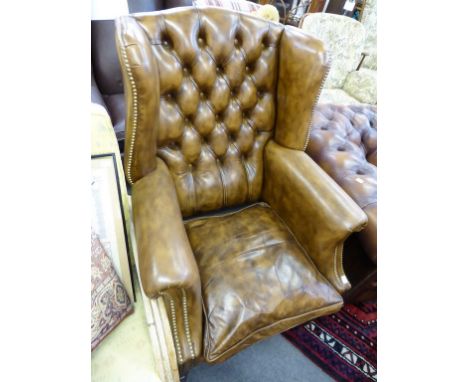 A brown leather button back library armchair.