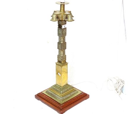 A Middle Eastern heavy cast-brass table lamp, with relief and engraved scrollwork decoration, oak base and fluted shade, heig