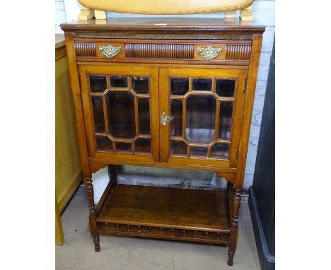 An Edwardian mahogany side cabinet, with single drawer above glazed cupboard doors, with spindle lower shelf, on turned legs,