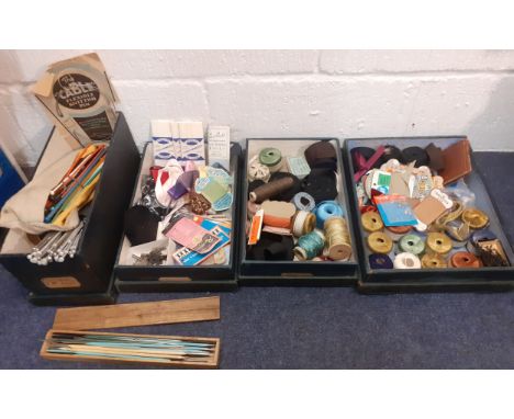 Four 1920's green canvas covered wooden haberdashery boxes containing vintage knitting needles, silks, haberdashery tape and 