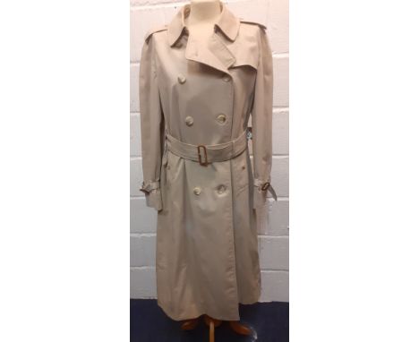 Burberry-A 1970's beige double breasted 'Kensington' lightweight cotton trench coat having brown leather buckles to belt and 