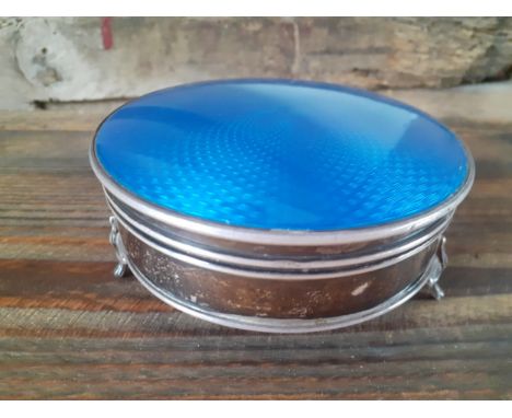 An early 1900's silver and blue enamelled circular dressing table trinket box with hinged lid on 3 cabriole legs, silk padded