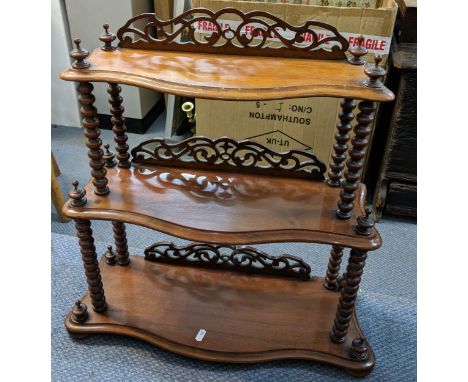A Victorian mahogany three tier graduated wall hanging shelf having pierced fretwork and bobbin turned supports 59cm h x 58.5