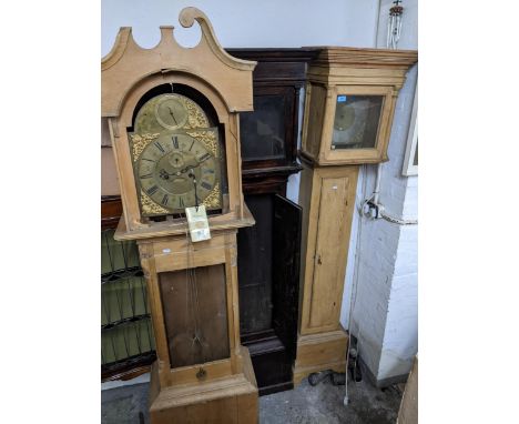 Two pine cased longcase clocks and a Georgian longcase clock case, each of the pine cases with matched clock movements, Locat